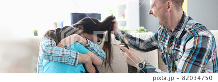 Man with belt in his hand yelling at little girl and woman at home Man with belt in his hand yelling at little girl and woman at home 82034750