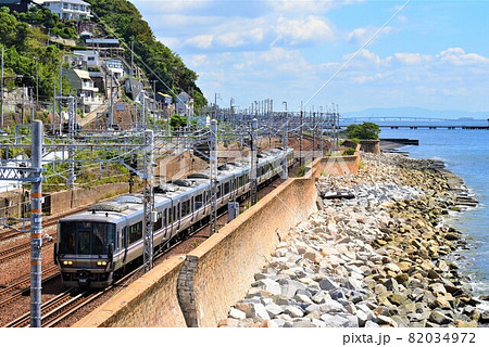 瀬戸内海を横に見て、JR神戸線を快走する電車 82034972