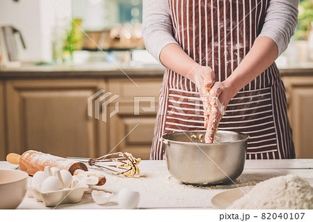 Woman hands kneading dough in iron bowl Woman hands kneading dough in iron bowl 82040107