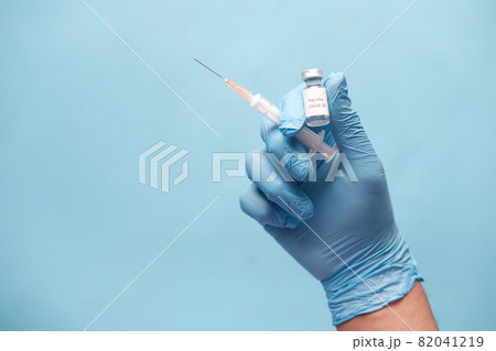 hand in latex gloves holding glass ampoule vaccine, with copy space hand in latex gloves holding glass ampoule vaccine, with copy space 82041219