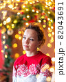 Holiday woman portrait in sweater with bokeh 82043691