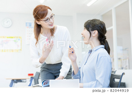 英会話教室の眼鏡をかけた西洋人の先生と若い女性 撮影協力:中央工学校付属日本語学校 英会話教室の眼鏡をかけた西洋人の先生と若い女性 撮影協力:中央工学校付属日本語学校 82044919