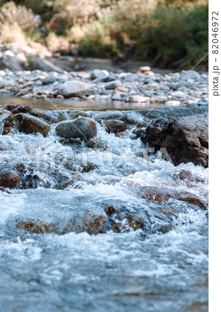 A fast-flowing wide and full-flowing mountain river. Large rocks stick out of the water. Big mountain river Katun, turquoise color, in the Altai Mountains, Altai Republic. 82046972