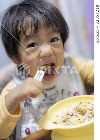 自分でスプーンを持って食事する1歳半の男の子 82057219