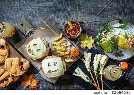 Halloween party food corner table scene over a wood background. Halloween party burger, mummies mini pizzas, halloween drink, Bell peppers with spaghetti and and minced tomato turkey. Top view, flat Halloween party food corner table scene over a wood background. Halloween party burger, mummies mini pizzas, halloween drink, Bell peppers with spaghetti and and minced tomato turkey. Top view, flat 82064655