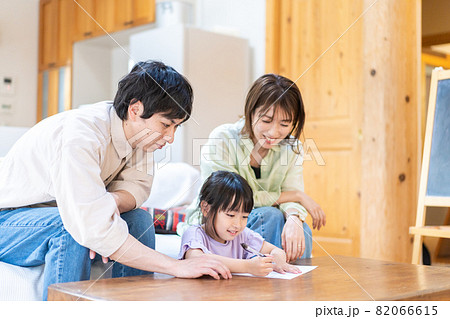 家でお勉強をする女の子と両親 82066615