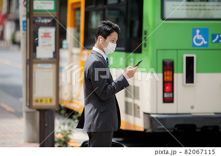 ビジネスマン　イヤホン　バス停　バス 82067115