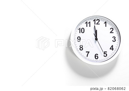White clock face of a wall clock show the time. It's close to 12 o'clock. The latest report of the atomic scientist shows the doomsday clock 100 seconds to twelve. Concept design with black line 82068062