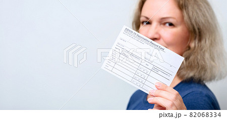 Vaccinated young woman showing COVID-19 Vaccination Record Card Vaccinated young woman showing COVID-19 Vaccination Record Card 82068334
