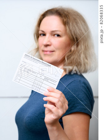 Vaccinated young woman showing COVID-19 Vaccination Record Card Vaccinated young woman showing COVID-19 Vaccination Record Card 82068335