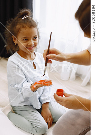 Woman and little girl painting hand and making prints 82069194