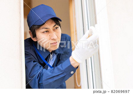 窓のメンテナンスをする技術スタッフ 82069697