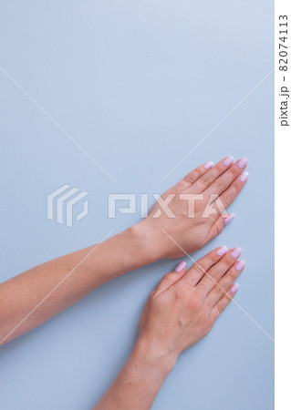 Stylish trendy female manicure. Beautiful young woman's hands on blue background. Stylish trendy female manicure. Beautiful young woman's hands on blue background. 82074113