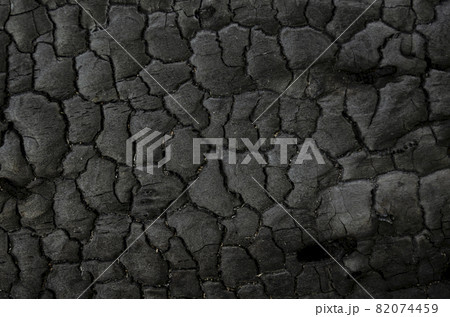 Natural fire ashes with dark grey black coals texture. It is a flammable black hard rock. Space for text. 82074459