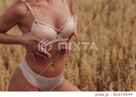 A young woman in underwear in a field of wheat. 82075644
