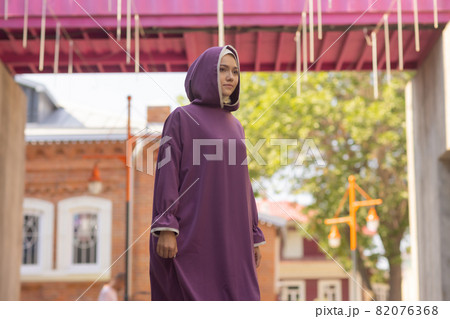 Islamic beautiful woman in a Muslim dress standing on a summer park street background forest autumn trees.world hijab day. Islamic beautiful woman in a Muslim dress standing on a summer park street background forest autumn trees.world hijab day. 82076368
