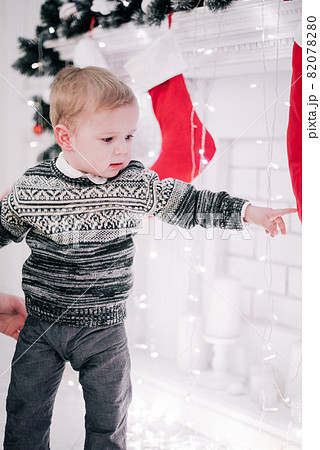 Christmas portrait of a young boy cozy atmosphere around the fireplace and Christmas tree Christmas portrait of a young boy cozy atmosphere around the fireplace and Christmas tree 82078280