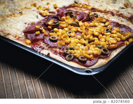 pizza pie on a black baking tray pizza pie on a black baking tray 82078560