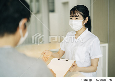 病院の受付にいる女性（マスク・患者） 82080170