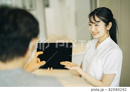病院の受付にいる女性（患者・タブレットPC） 82080292