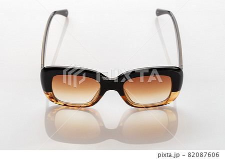 Sunglasses on a white reflective surface. Fashionable, stylish accessories. Sunglasses on a white reflective surface. Fashionable, stylish accessories. 82087606