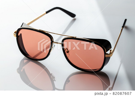 Sunglasses on a white reflective surface. Fashionable, stylish accessories Sunglasses on a white reflective surface. Fashionable, stylish accessories 82087607