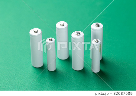 Several AA batteries in close up on a green background. Alkaline battery. Several AA batteries in close up on a green background. Alkaline battery. 82087609