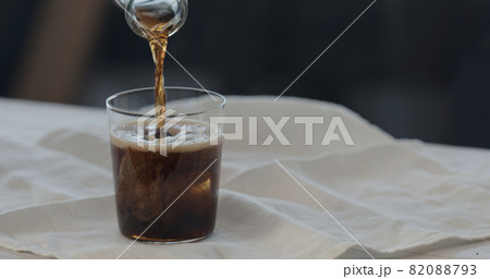 man pour cola over ice rocks into tumbler glass man pour cola over ice rocks into tumbler glass 82088793