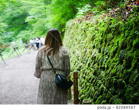 コケが綺麗な道を歩く女性の後ろ姿 82089567