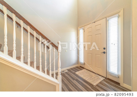 Home interior with stairs in front of the white front door flanked by sidelights Home interior with stairs in front of the white front door flanked by sidelights 82095493