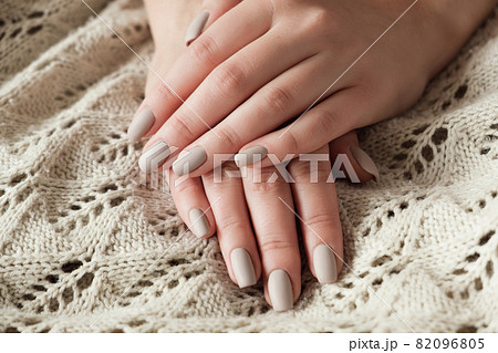 Matt nude beige nails close up. Winter or autumn manicure, woman hand on warm sweater Matt nude beige nails close up. Winter or autumn manicure, woman hand on warm sweater 82096805