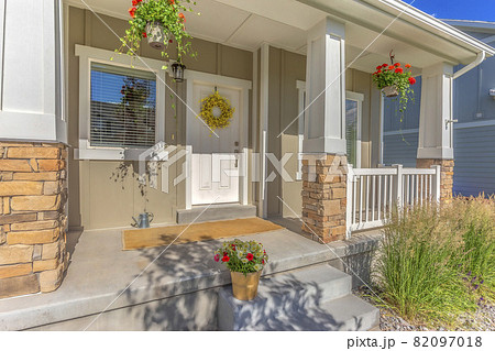 Outdoor stairs porch and white front door with wreath at the facade of a home 82097018