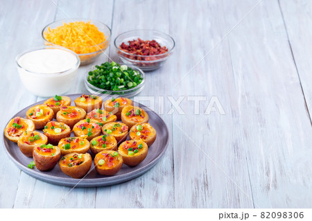 Baked mini red skinned loaded potatoes with crispy bacon, scallions and sharp cheddar cheese 82098306