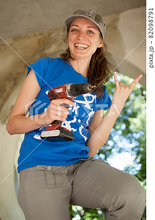 Skilled young female worker is using power screwdriver drilling during construction wooden bench gender equality, feminism, do it yourself concepts. Skilled young female worker is using power screwdriver drilling during construction wooden bench gender equality, feminism, do it yourself concepts. 82098791
