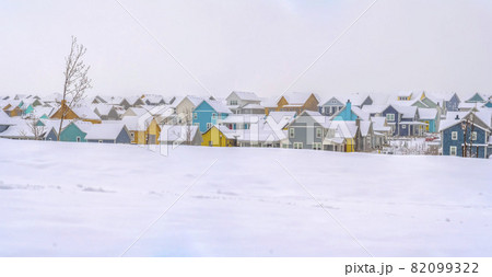 Winter landscape with colorful houses against a cloudy sky background Winter landscape with colorful houses against a cloudy sky background 82099322