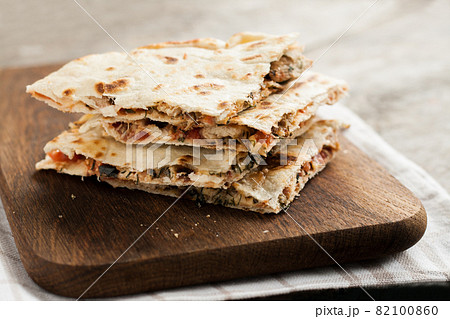 pile of quesadillas with chicken and vegetables on the rustic board 82100860