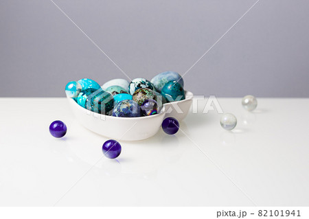 Easter blue quail eggs in a plate in the shape of a heart on a white table Easter blue quail eggs in a plate in the shape of a heart on a white table 82101941