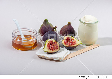 Fresh fig fruits, honey and yogurt on white background. Fresh fig fruits, honey and yogurt on white background. 82102048