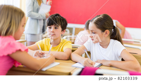 Preteen schoolchilds working in groups at lesson Preteen schoolchilds working in groups at lesson 82103339