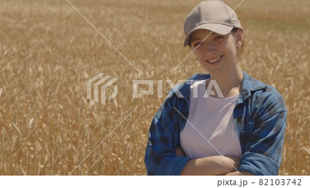 Happy girl farmer smiling in a wheat field, agriculture, successful business of sown rye plantations, grain harvest season, flour and bread production, the life of a young agronomist 82103742