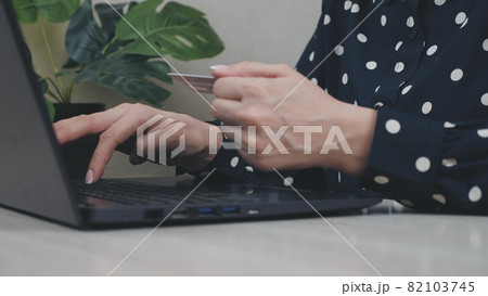 Female hands of cardholder holding credit card making e bank online payment. Woman consumer paying for purchase in web store using laptop technology. Ecommerce website payments concept. Close up view 82103745