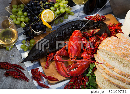 Top view of smoked sturgeon, lobster, crayfishes, bread, cheese, fruits and wine Top view of smoked sturgeon, lobster, crayfishes, bread, cheese, fruits and wine 82109731