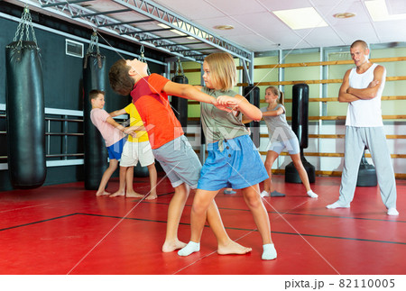 Kids in pair exercising self-defense movements 82110005