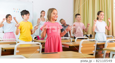 Small school kids doing physical exercises with teacher 82110549