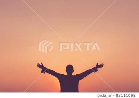 Copy space of man rise hand up on sunset sky at beach and island background. 82111098