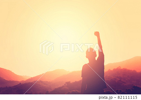 Copy space of man rise hand up on top of mountain and sunset sky abstract background. Copy space of man rise hand up on top of mountain and sunset sky abstract background. 82111115