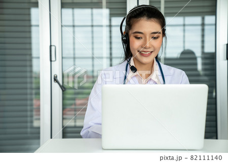 Doctor wearing headset talking actively on video call in hospital or clinic 82111140