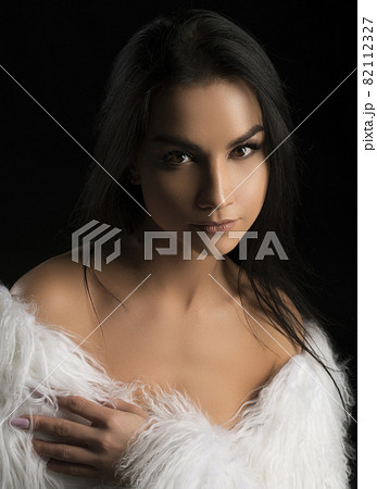 Beautiful brunette in white fur coat portrait Beautiful brunette in white fur coat portrait 82112327