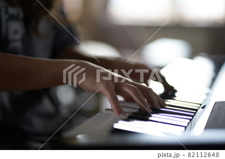 The musician's hands on the synthesizer. A cropped image of a person playing a synthesizer. Side view. High quality photo The musician's hands on the synthesizer. A cropped image of a person playing a synthesizer. Side view. High quality photo 82112648