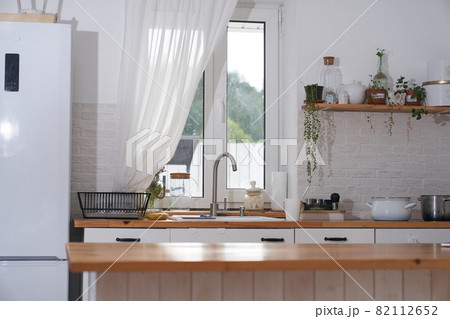 Cozy modern interior of a Scandinavian-style kitchen with a dining area, white modern interior, casual still life, coronavirus quarantine, household chores. High quality photo 82112652
